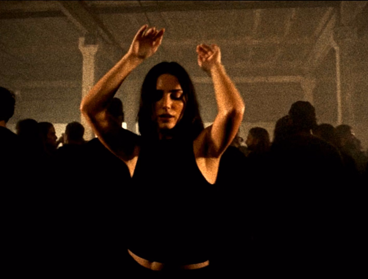 A woman dancing inside a crowded low light club