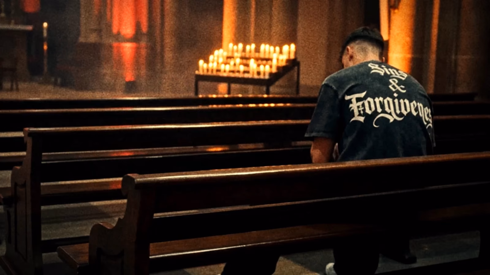 Figure wearing a Deathgrip shirt inside a candlelit church