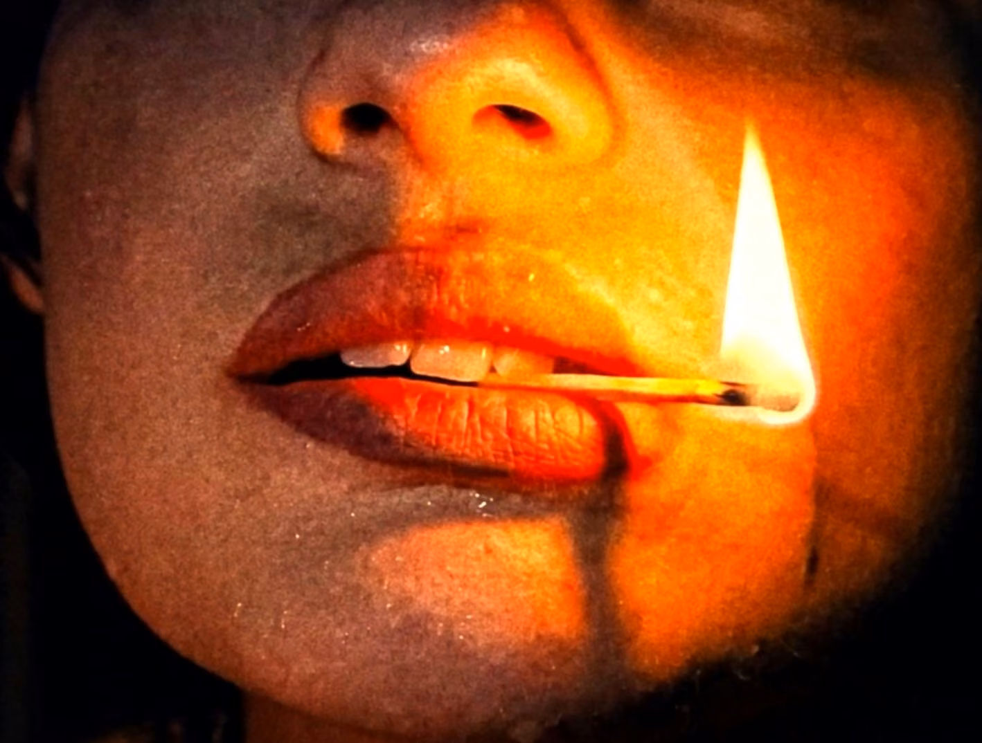 A burning match held close to a woman's face