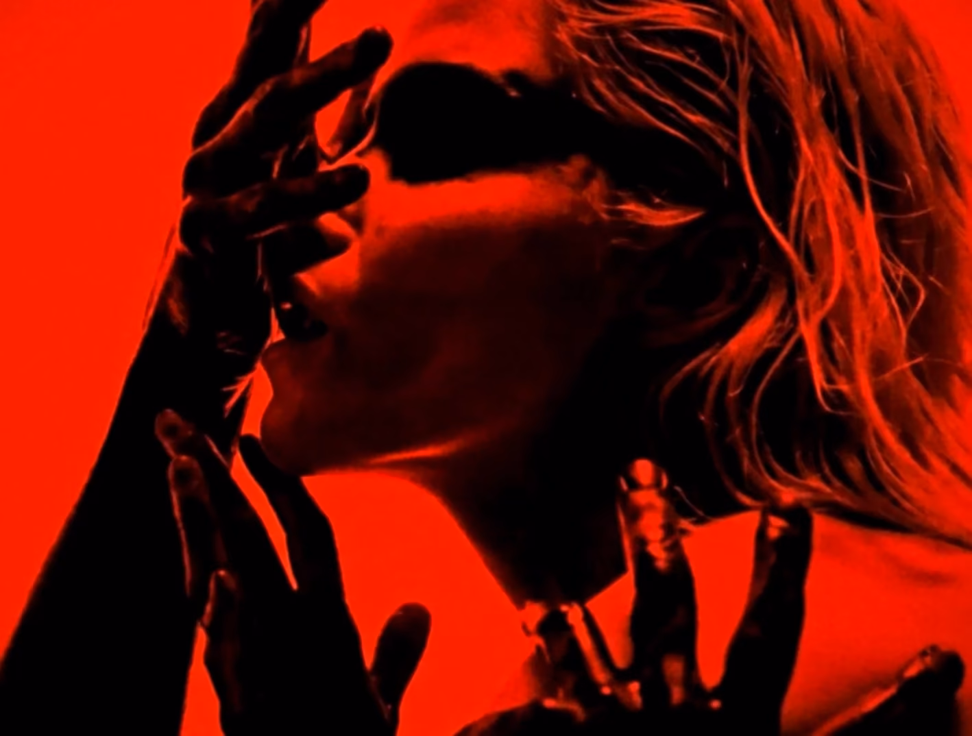 Fashion portrait in sunglasses under saturated red light