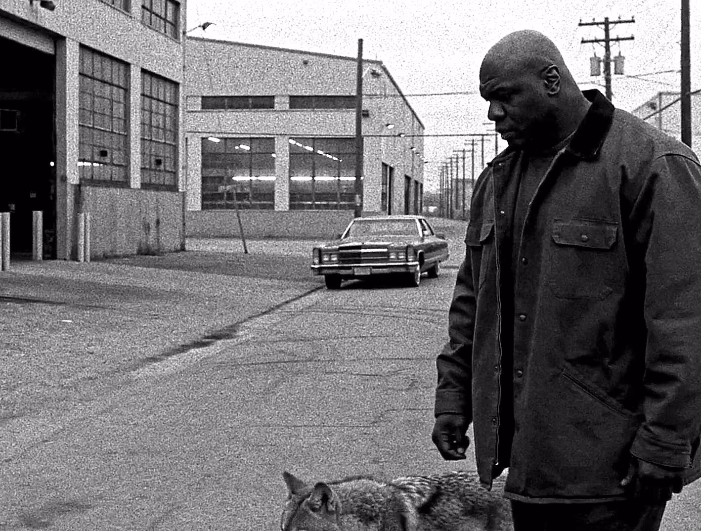 Shaquille O’Neal walking through an industrial street with a dog